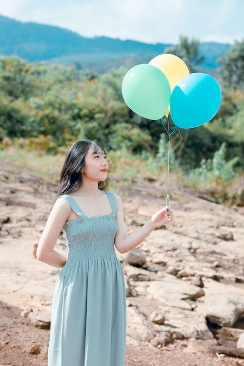 Woman In Dress Holding Balloons