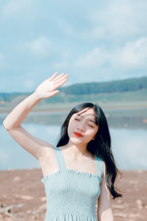 Woman Raising Hand To Cover Sunlight