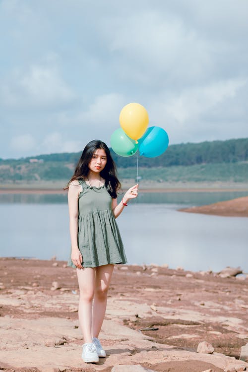 Mujer En Vestido Verde Sin Mangas Sosteniendo 3 Globos