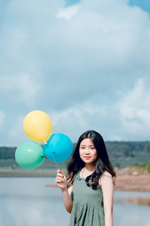Free Woman In Green Sleeveless Top Holding Balloons Stock Photo