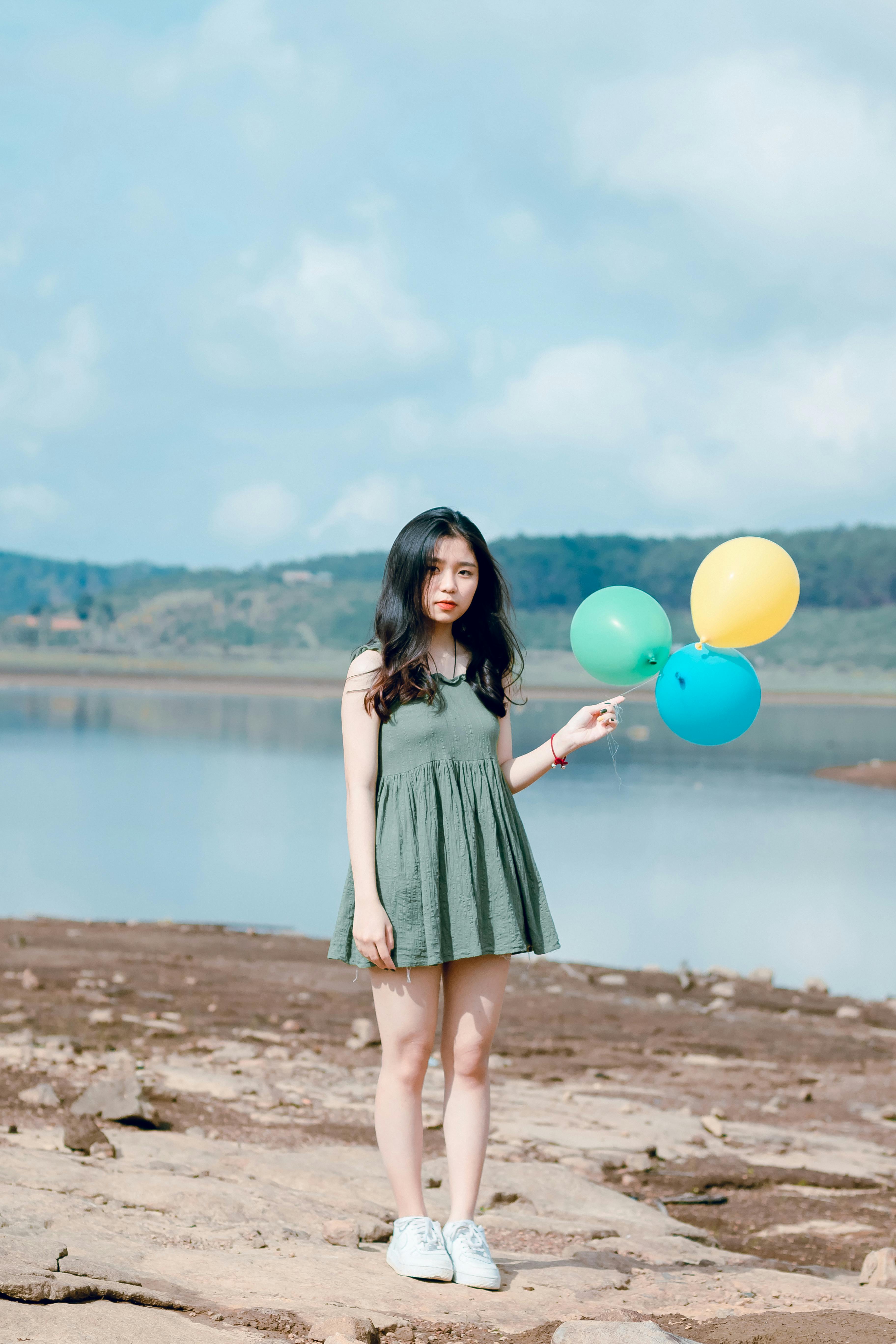 Photo of Girl Wearing Green Mini Dress Holding Balloons