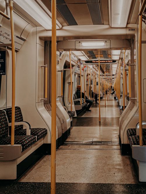 Free Empty interior of a London Underground train, showcasing iconic patterned seats and bright poles. Stock Photo