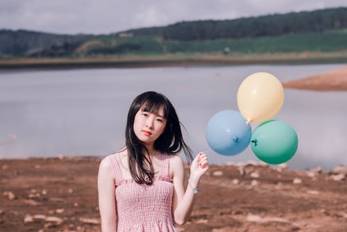 Garota Com Blusa Sem Mangas Rosa Segurando Três Balões De Festa