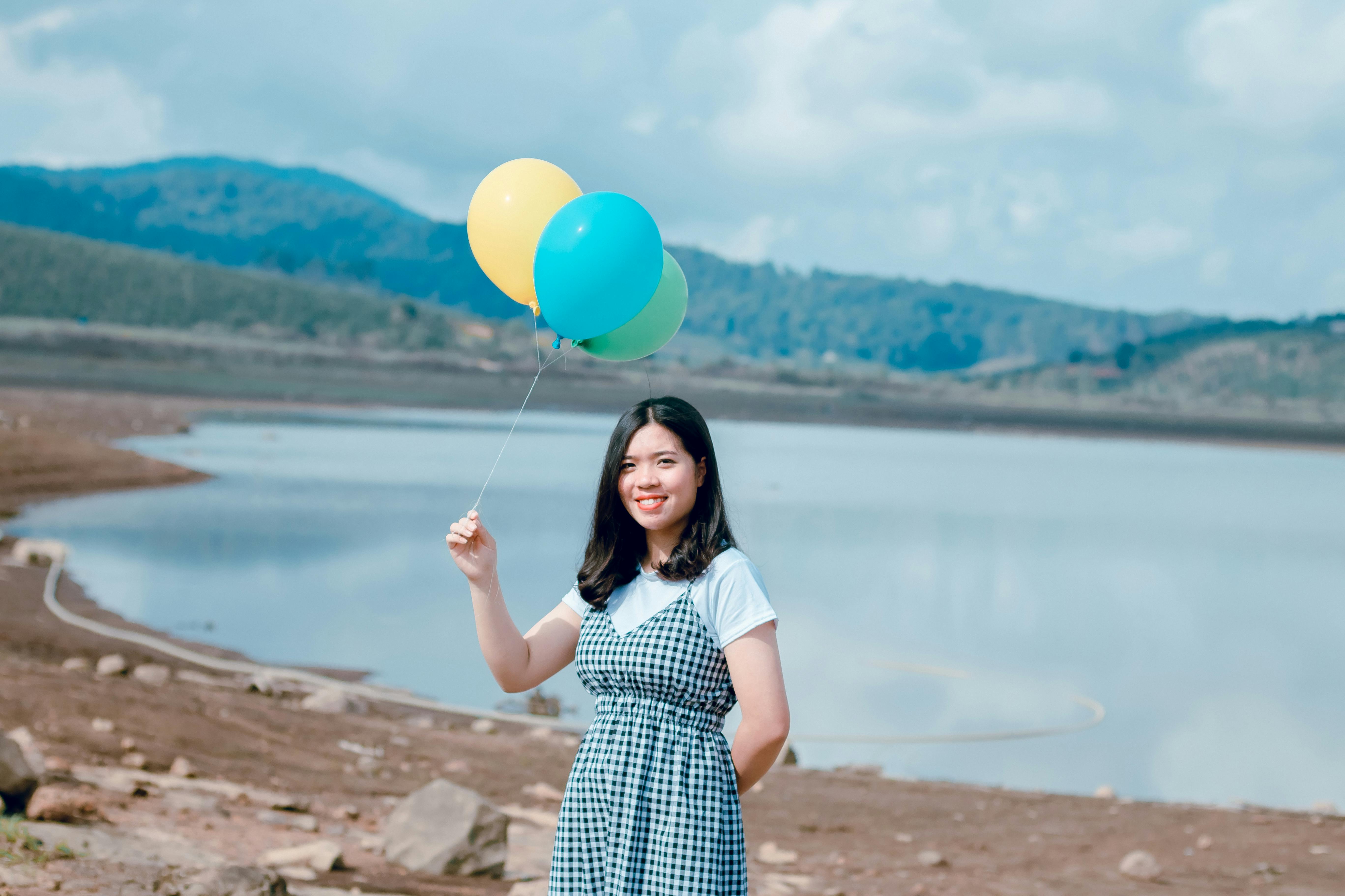 Frau In Der N\u00e4he Der K\u00fcste, Die Luftballons H\u00e4lt \u00b7 Kostenloses Stock Foto