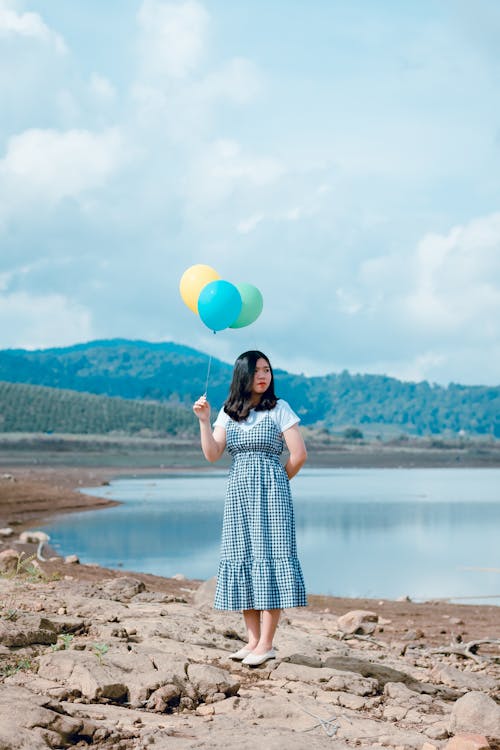 Palloncini Della Holding Della Donna Vicino Al Fiume