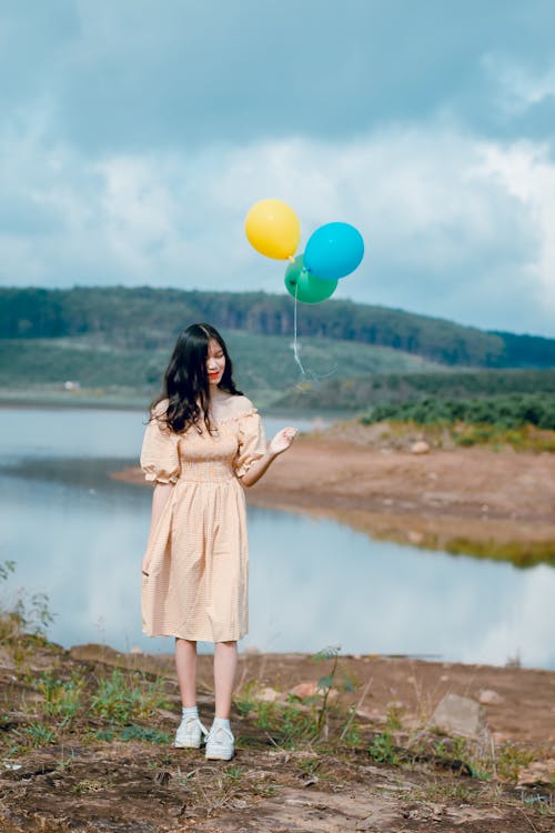 免费 米色的露肩礼服，拿着气球的女人 素材图片