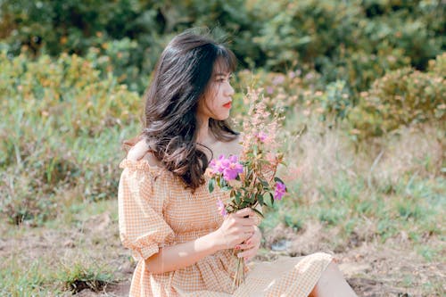 Woman In Dress Holding Flowers