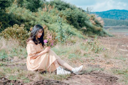 Free A young woman in a serene field, enjoying relaxation with wildflowers in fall. Stock Photo