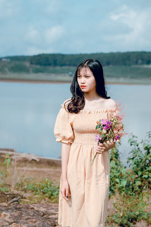 Shallow Focus Photography of Woman in Yellow Off-shoulder Dress Holding Flower Bouquet