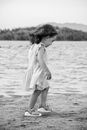 Girl in a Dress Walking on Sand Near a Body of Water