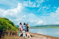 一群妇女在阳光明媚的蓝天下，于宁静的湖边享受着充满活力的一天