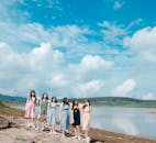 七名妇女站在宁静的蓝天湖畔，展现着友谊与团结