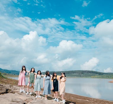 七名妇女站在宁静的蓝天湖畔，展现着友谊与团结