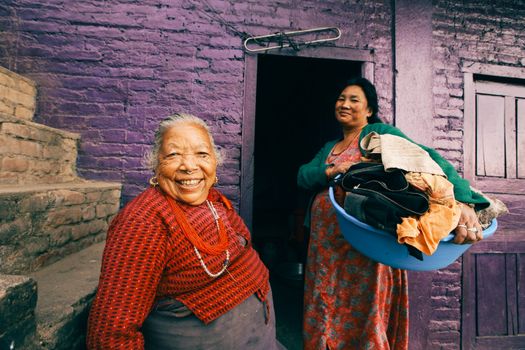 Two Women Posing in Front of Slum Violet House