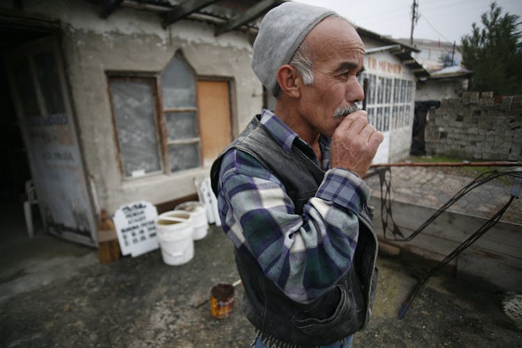 Man In Hat Standing Near House