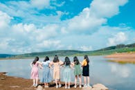 一群年轻女性在宁静的湖边，沐浴在充满活力的蓝天下，享受着阳光明媚的一天