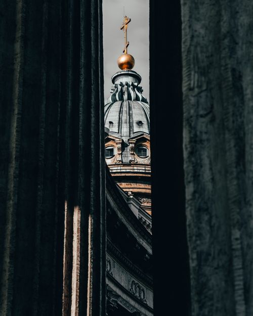 Free Dramatic view of a church dome framed by ancient columns, symbolizing religious architecture. Stock Photo