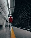 Man in Red Jacket Waiting at a Train Station