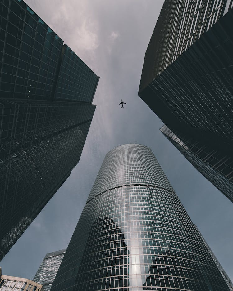 Airplane Flying Over Skyscrapers