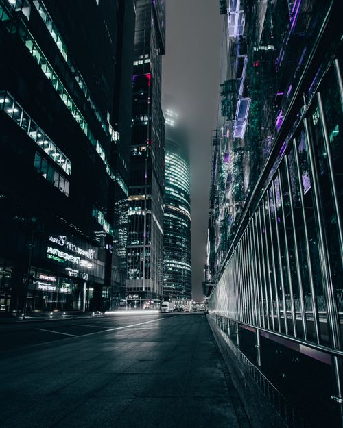 Free A moody nighttime scene showcasing modern skyscrapers lit up in an urban cityscape. Stock Photo