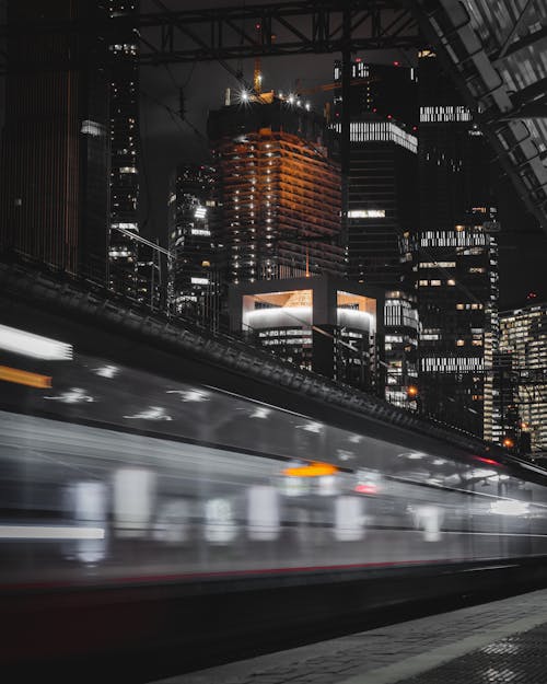 Long Exposure of a Train Passing in a Modern City Downtown at Night 