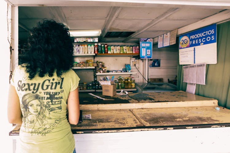 Woman With Black Hair Standing By Store Counter