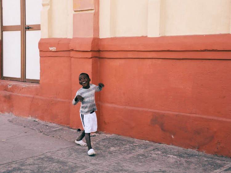 Smiling Boy Walking On A Street 