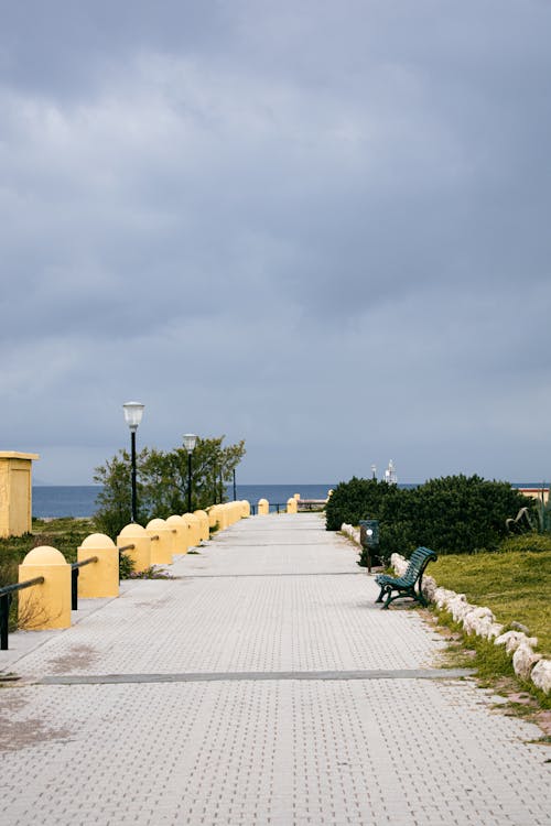 Paved Walkway with Benches Near the Sea