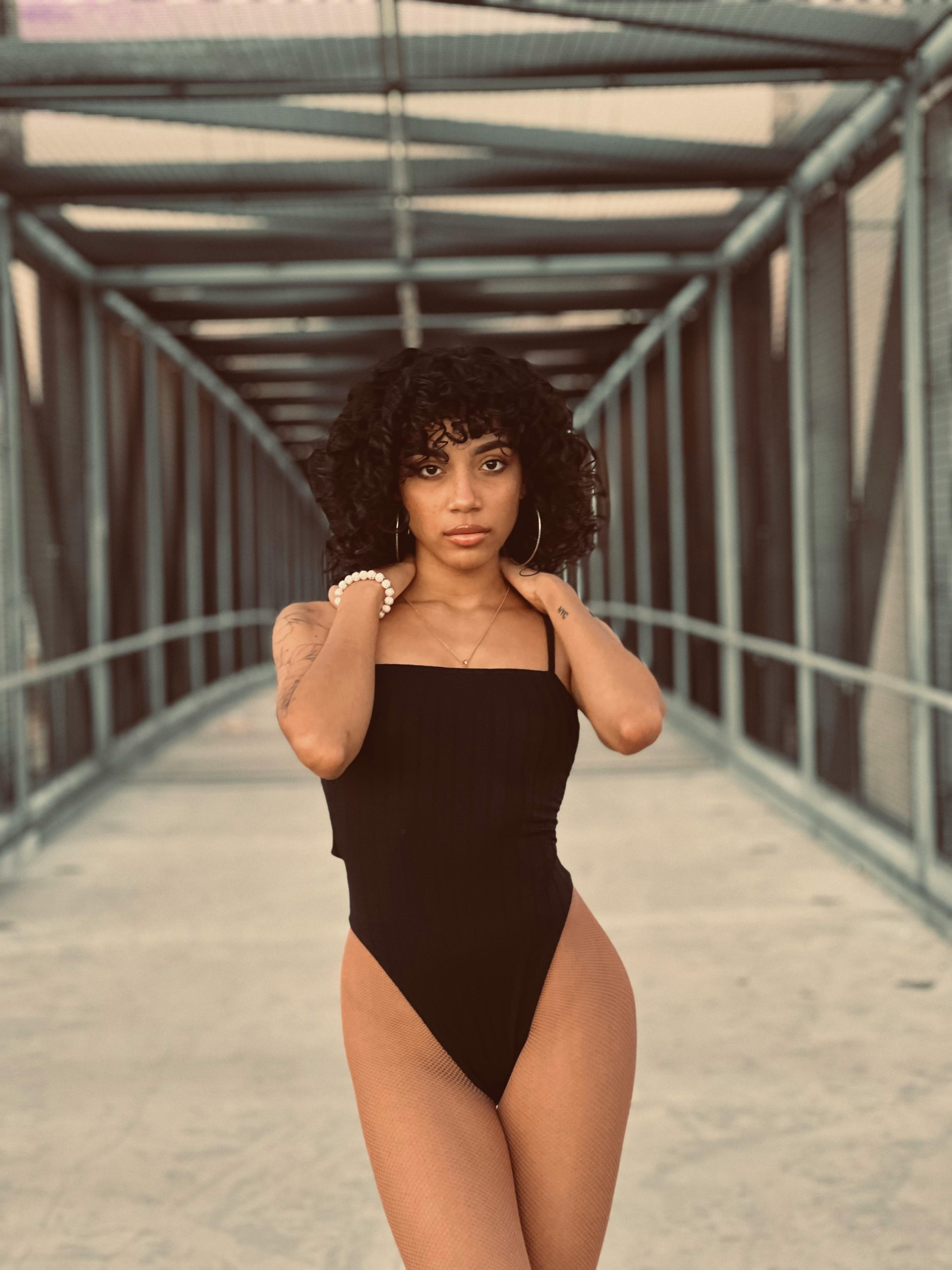Young Woman in a Black Bodysuit Posing in a Tunnel · Free Stock Photo