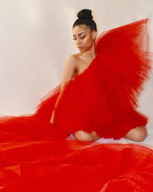 Brunette Woman in a Red Gown Posing in a Studio 