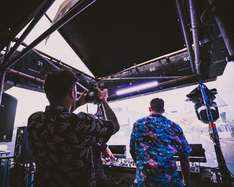 Engaging backstage view of a sound crew setting up for a live music event with a vibrant atmosphere. Engaging backstage view of a sound crew setting up for a live music event with a vibrant atmosphere.