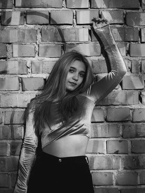 Young Woman Standing Against a Brick Wall 
