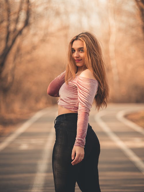 Woman Standing in the Middle of the Road Looking Back