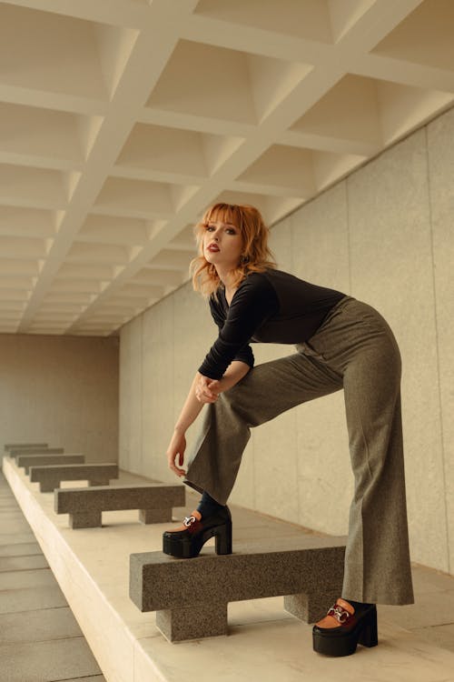 Redhead Woman Posing in Wide Pants and Black High Heels