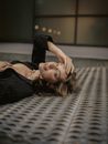 Woman with Brown Hair Laying on Floor in Unbuttoned Black Shirt