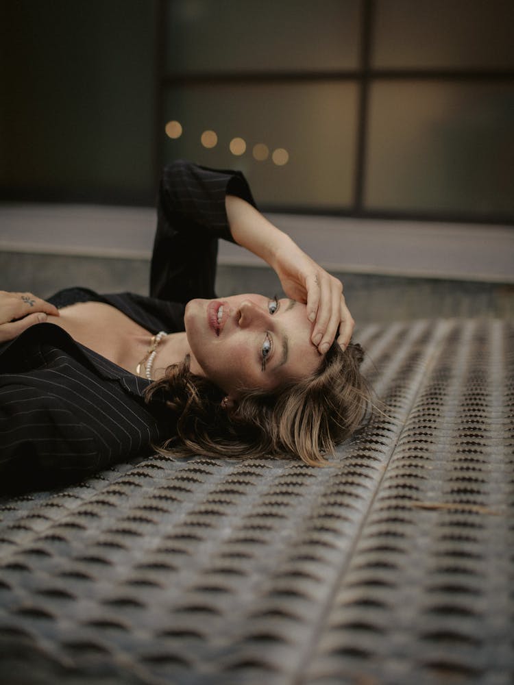 Woman With Brown Hair Laying On Floor In Unbuttoned Black Shirt