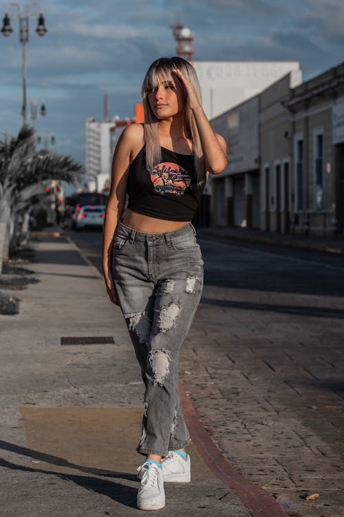 Woman in Torn Jeans and a Black Tank Top 
