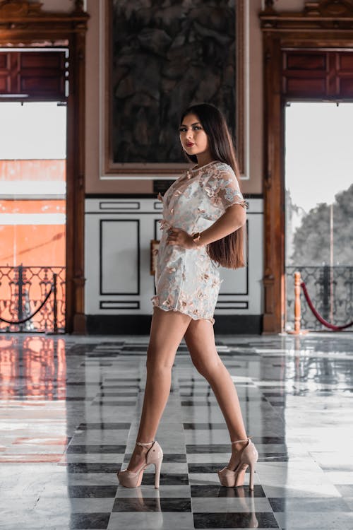 Free Woman in White Floral Dress Standing on Gray Concrete Floor Stock Photo