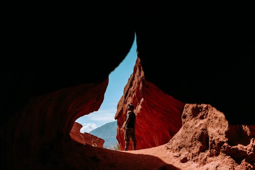 Man Standing outside a Cave