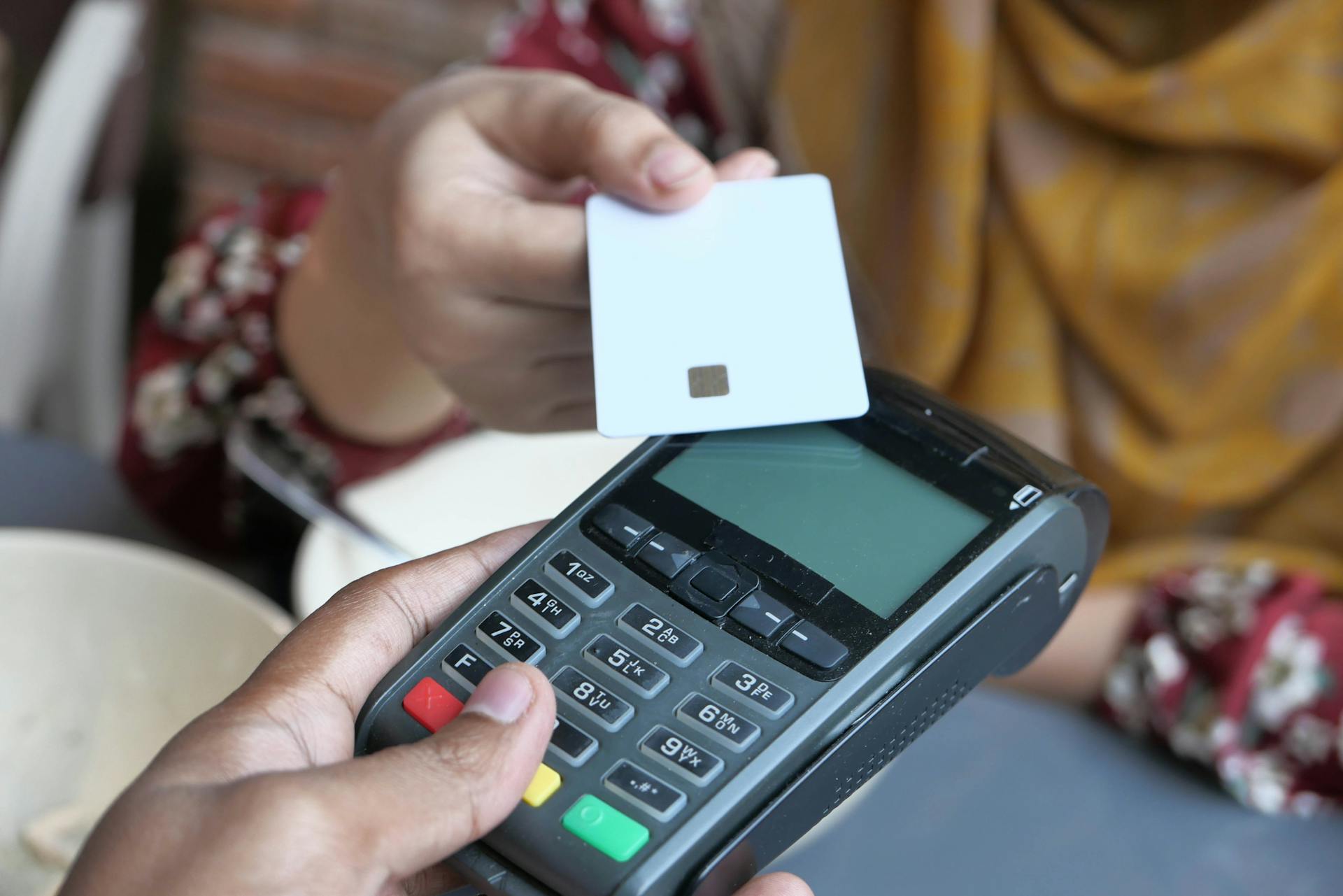 Close-up of a contactless credit card payment being made at a store terminal.