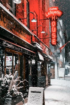 Snowy night at Chateau Lafayette, Ottawa illuminated by neon sign and streetlights.