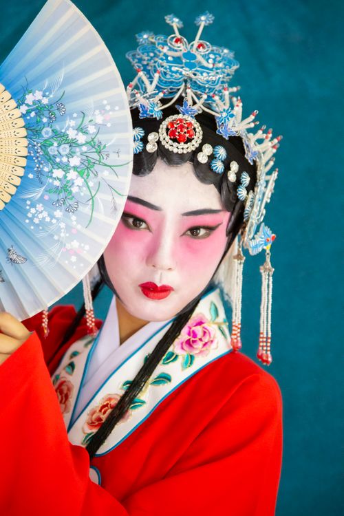 Free Chinese opera performer in traditional attire, posing with a decorative fan. Stock Photo