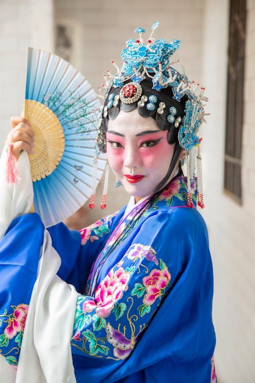 Woman in Traditional Clothing Posing with a Fan