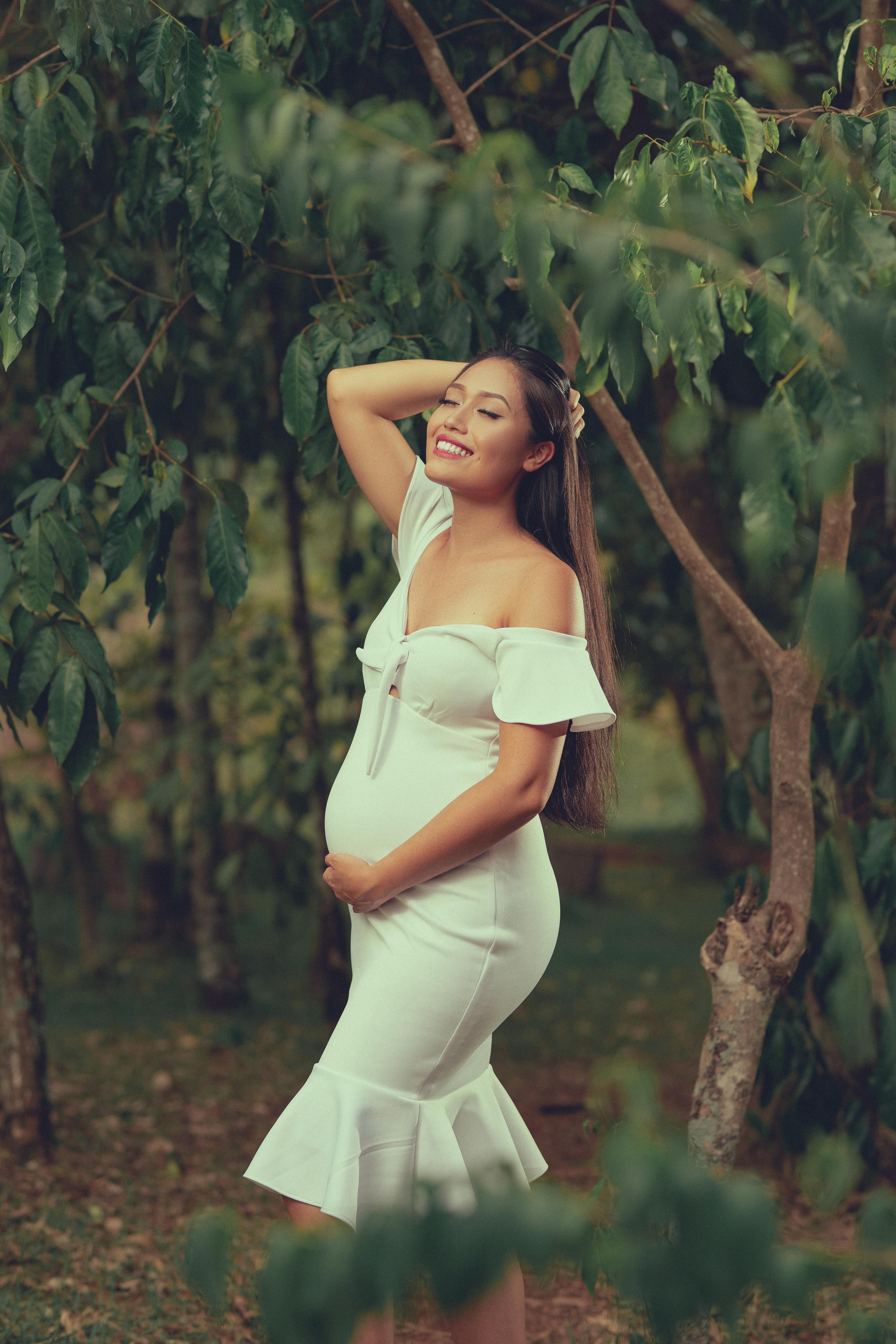 Pregnant Woman Posing Near a Tree · Free Stock Photo