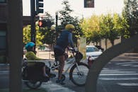 白天，一名骑着儿童背带自行车的骑手在城市十字路口停了下来