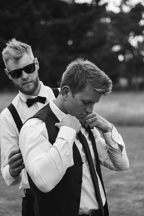 Black and White Shot of Men Fixing an Elegant Outfit