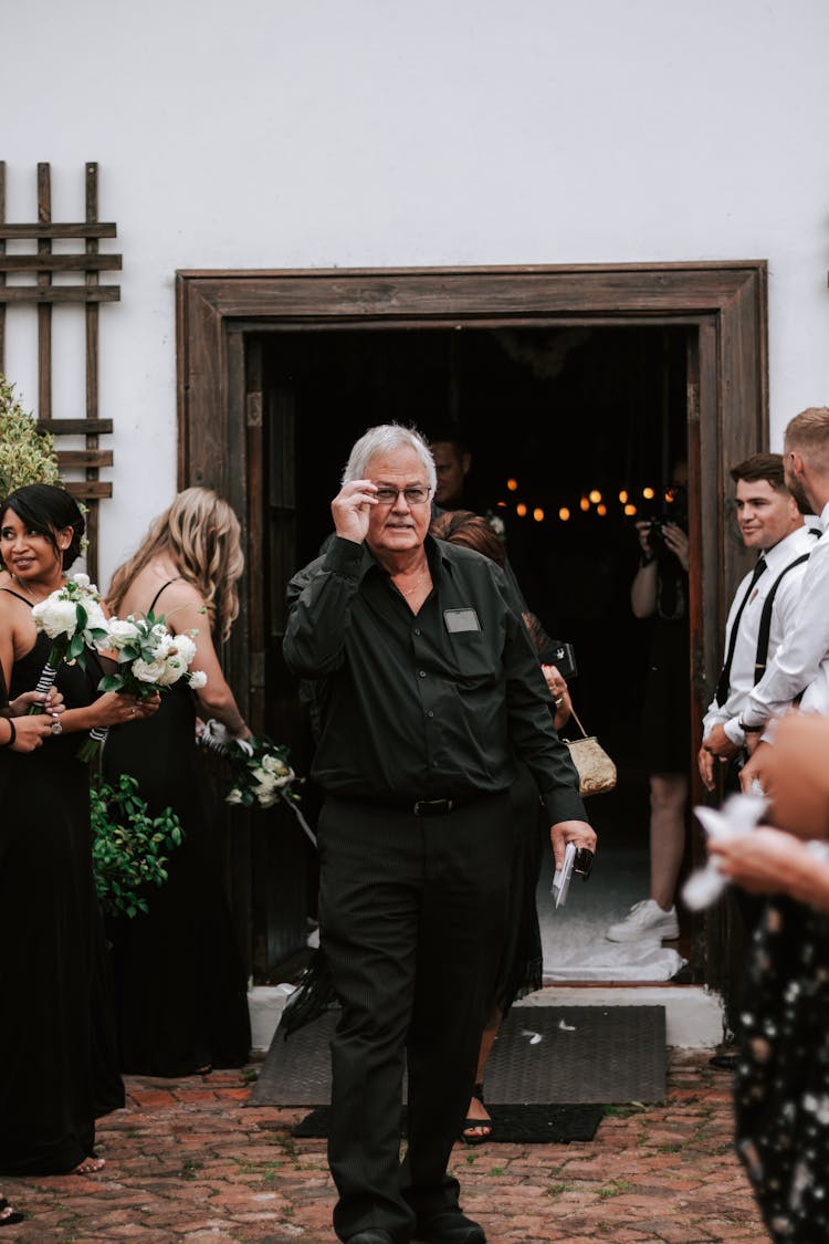 Man In Black Suit Standing In Aisle During Reception