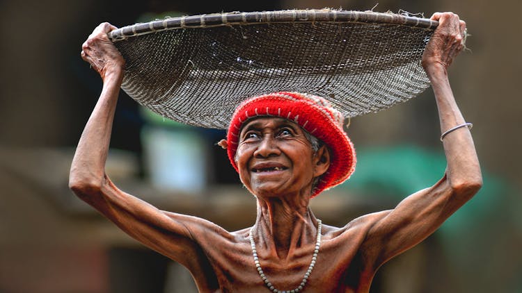 Elderly Woman Carrying Basket On Head