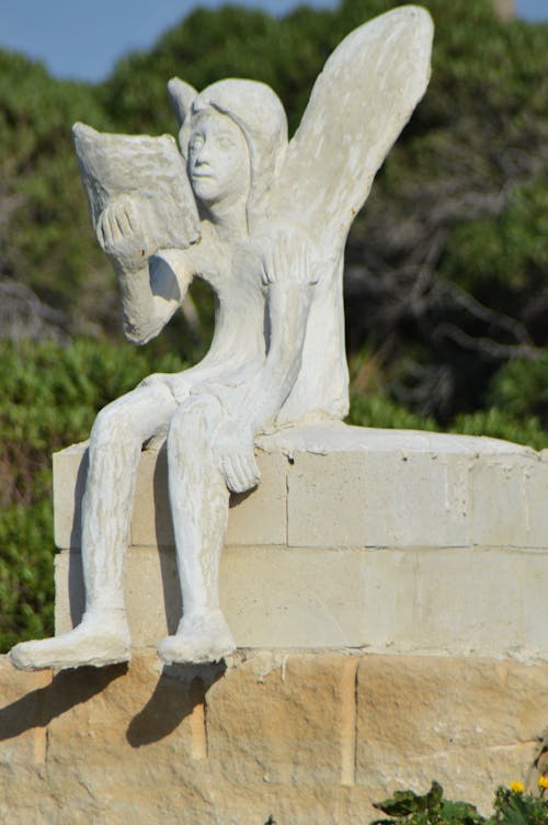 Statue of angel or fairy reading a book