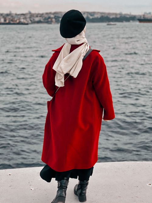 Free A woman in a red coat and beret gazes at the Bosphorus in Istanbul, Turkey. Stock Photo